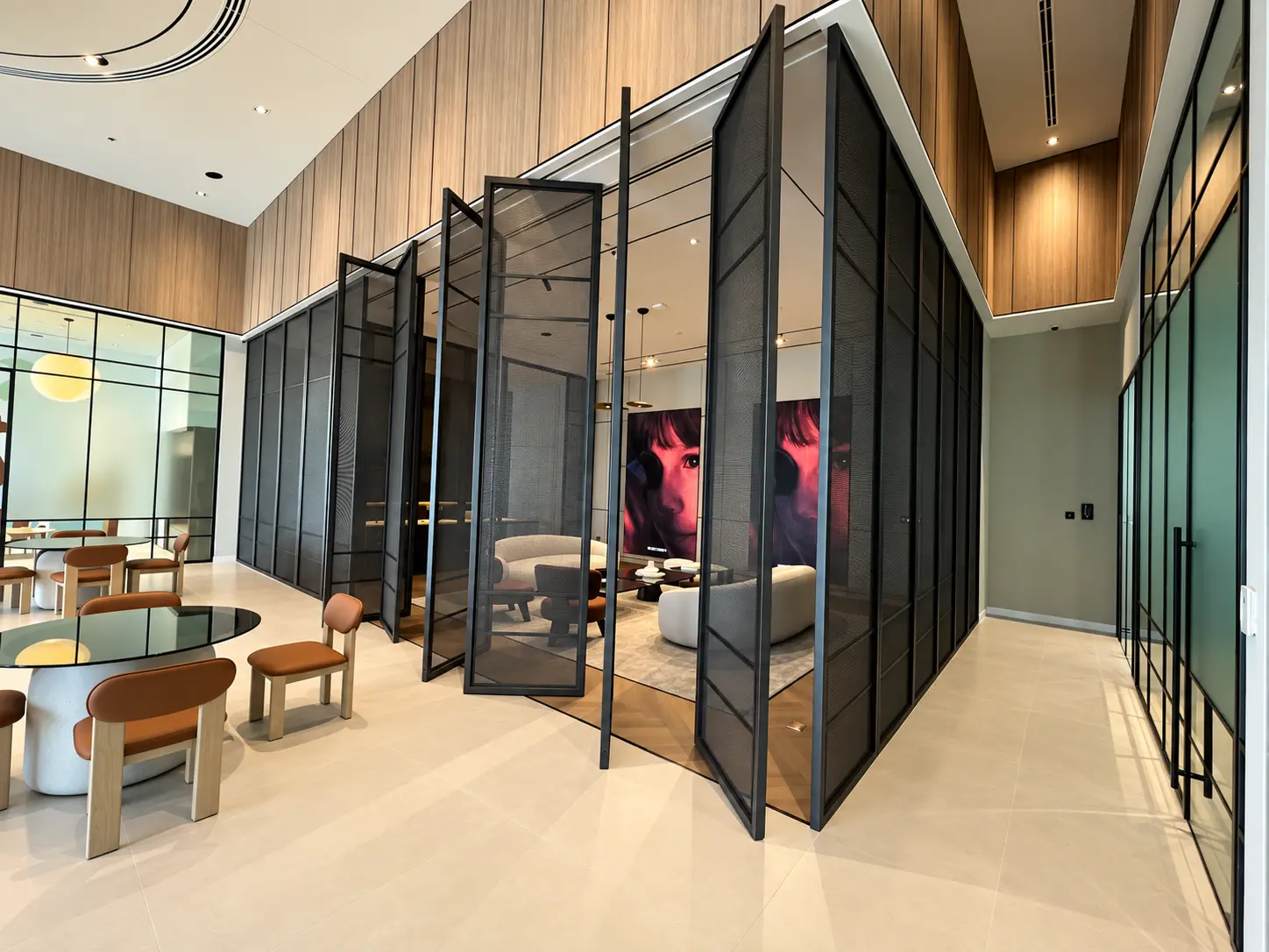 Black pivoting metal mesh screens enclosing a seating area